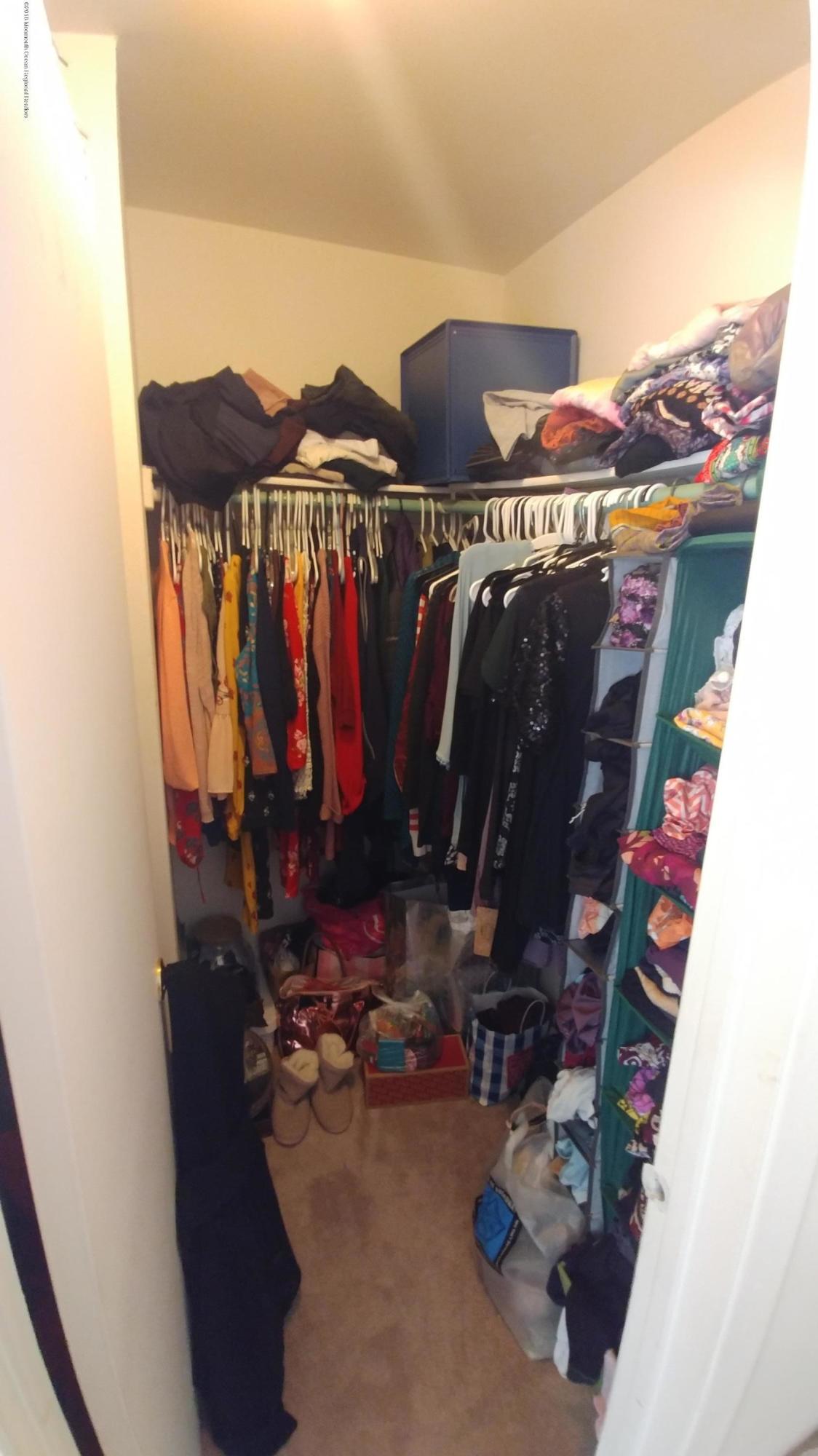 177 Amberly Drive, Unit K Manalapan, NJ 07726 - Photo 11 of 19 a view of walk in closet with clothes and shoes