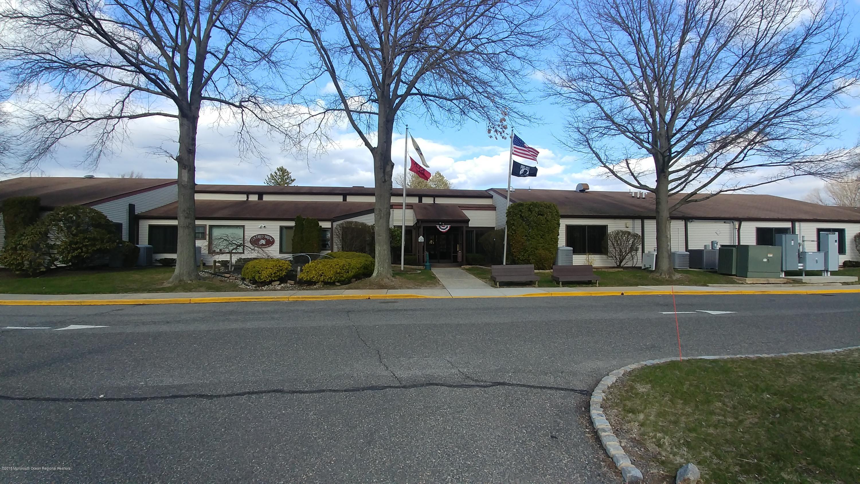 177 Amberly Drive, Unit K Manalapan, NJ 07726 - Photo 18 of 19 a front view of a house with a yard table and chairs
