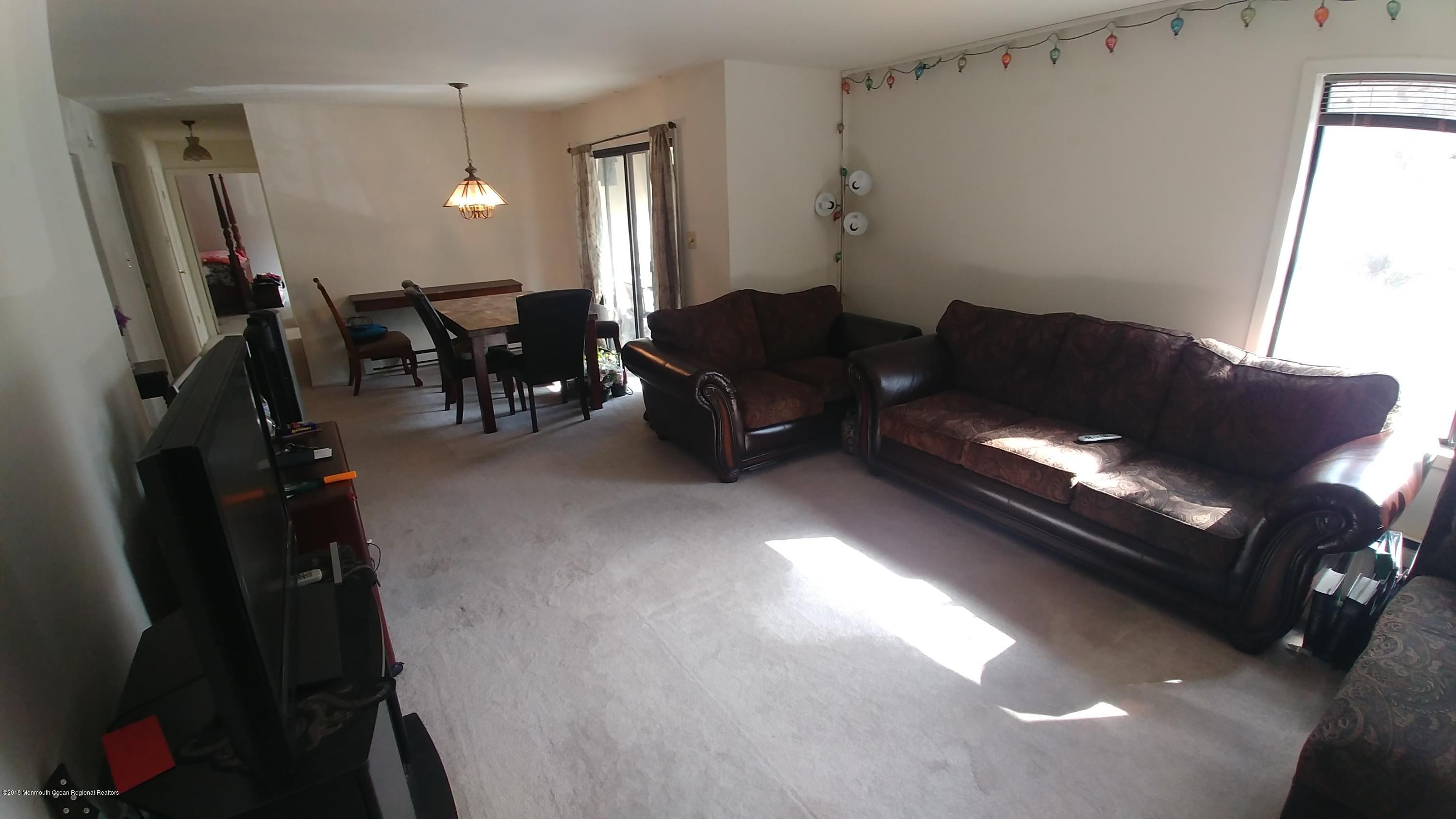 177 Amberly Drive, Unit K Manalapan, NJ 07726 - Photo 2 of 19 a living room with furniture and a flat screen tv