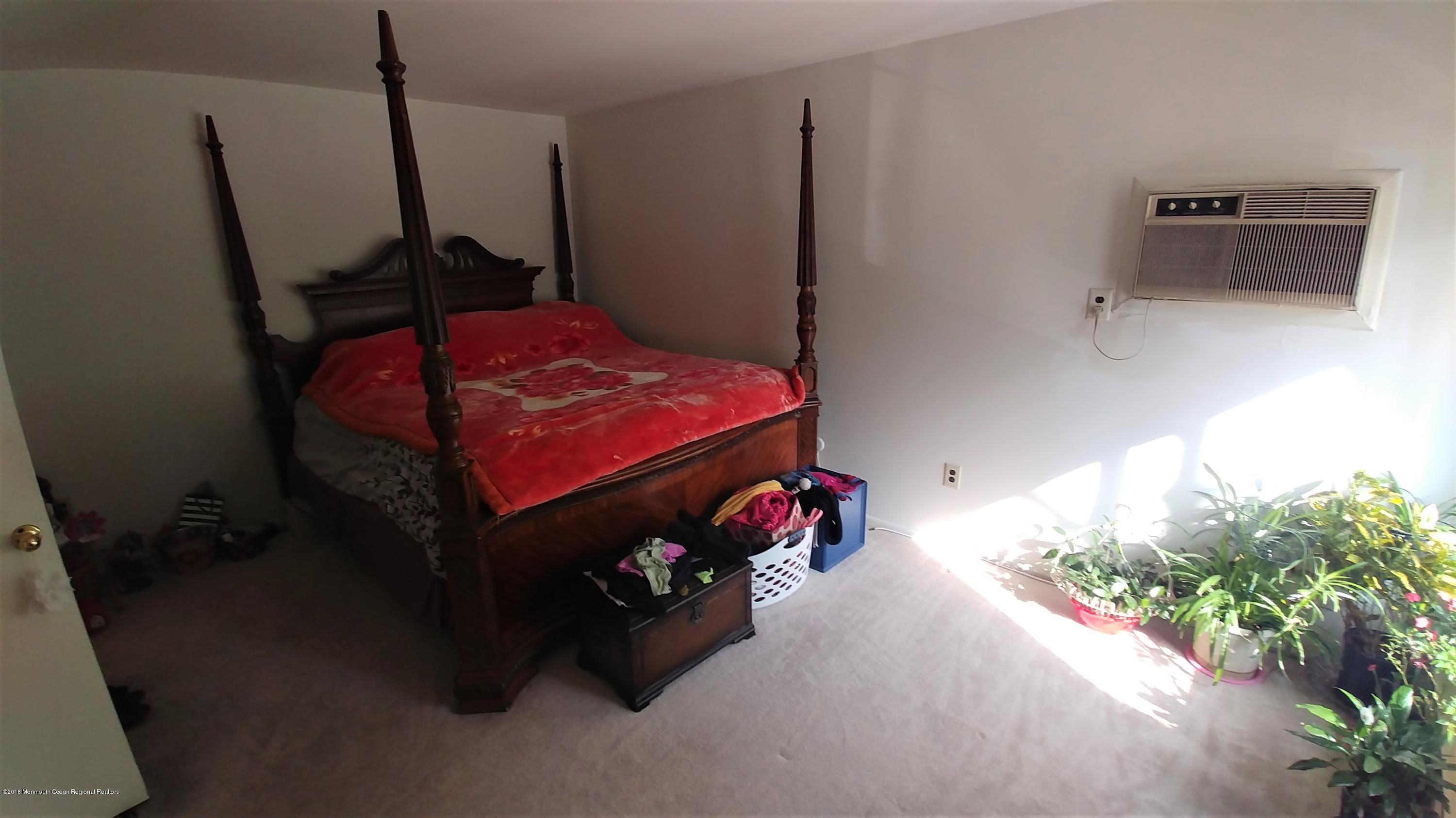 177 Amberly Drive, Unit K Manalapan, NJ 07726 - Photo 5 of 19 a bedroom with a bed and a potted plant