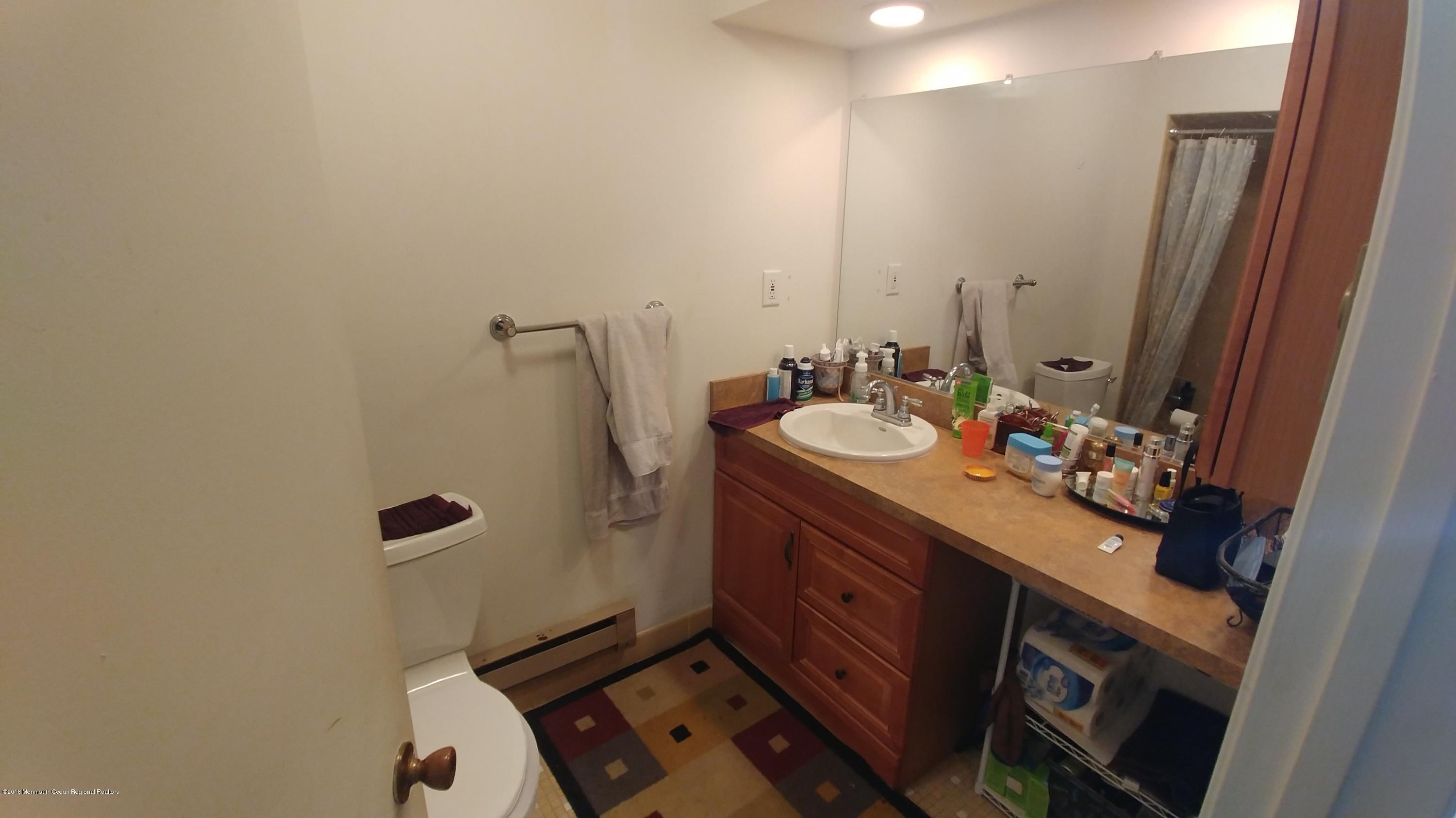 177 Amberly Drive, Unit K Manalapan, NJ 07726 - Photo 8 of 19 a bathroom with a sink mirror and toilet