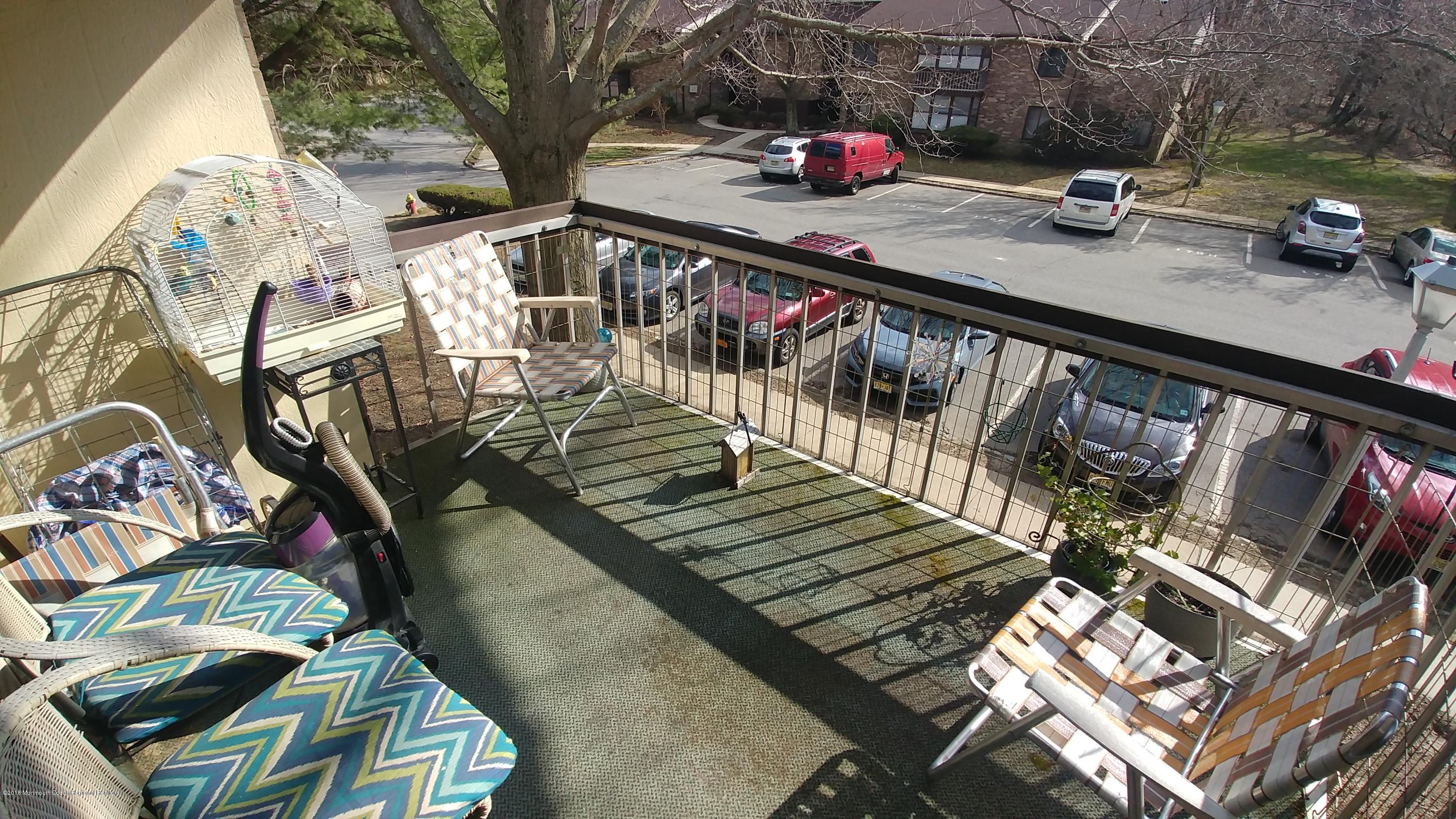 177 Amberly Drive, Unit K Manalapan, NJ 07726 - Photo 9 of 19 a view of balcony with seating space and wooden floor