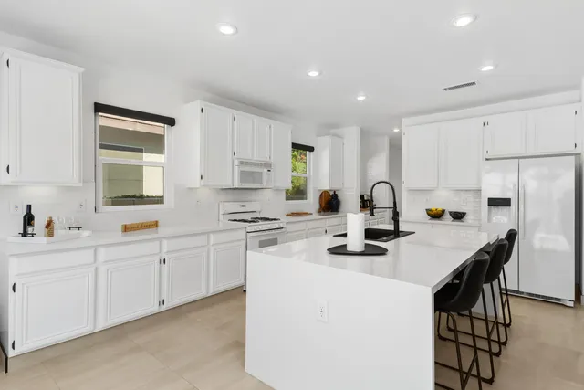 a kitchen with stainless steel appliances granite countertop a sink stove and refrigerator