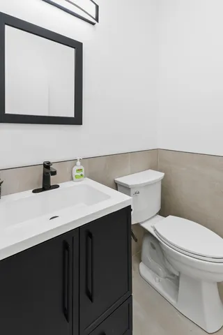 a bathroom with a sink a toilet and mirror