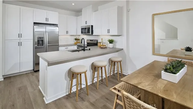 a kitchen with kitchen island a stove a table and chairs
