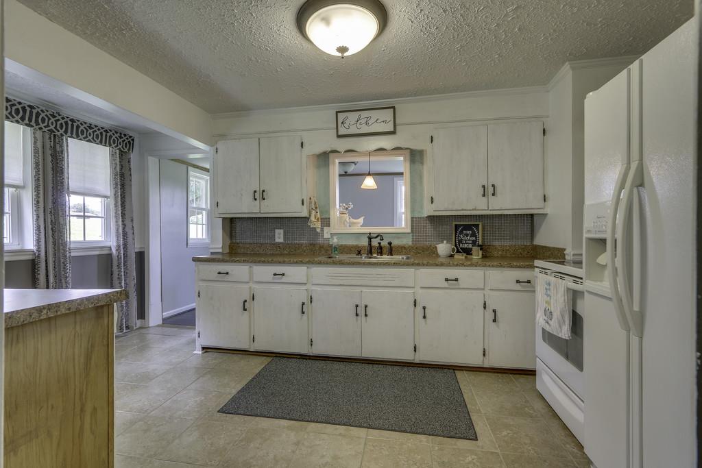 301 Whitson Road Bethpage, TN 37022 - Photo 11 of 29 a large kitchen with granite countertop a stove a sink and a refrigerator