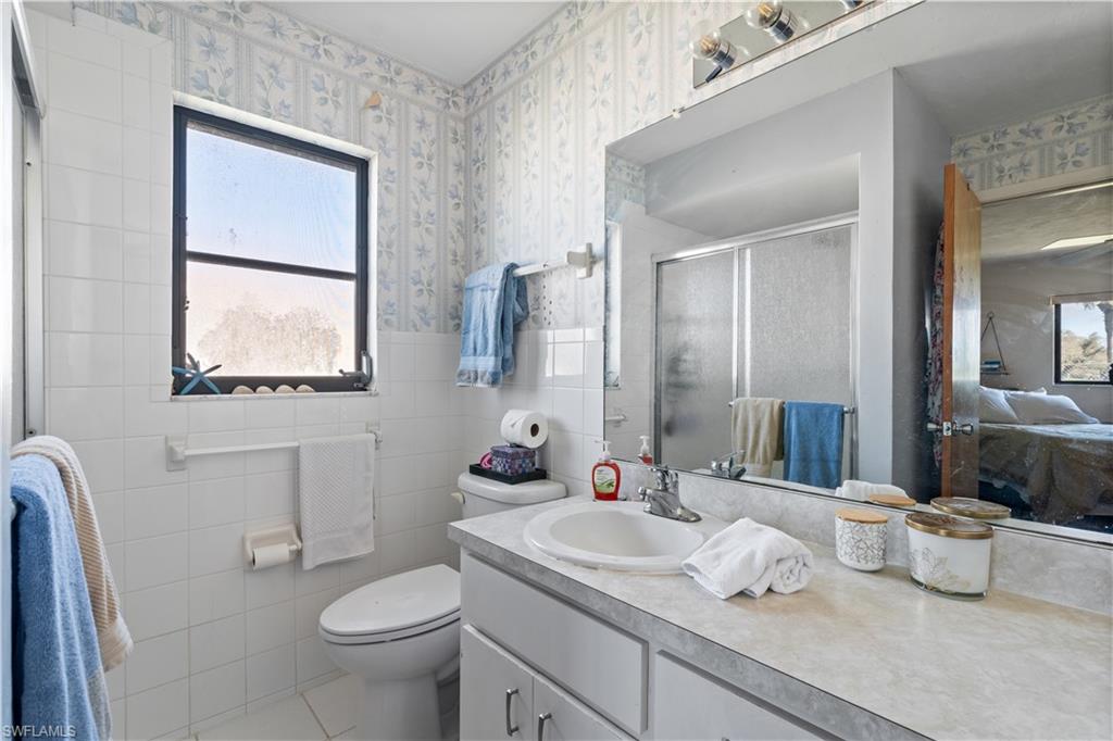 17600 Laurel Valley Road Fort Myers, FL 33967 - Photo 19 of 26 a bathroom with a granite countertop sink mirror and toilet
