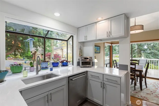 a kitchen with stainless steel appliances white cabinets a table and chairs