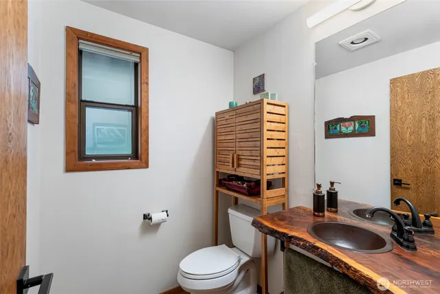 a bathroom with a sink a toilet and mirror