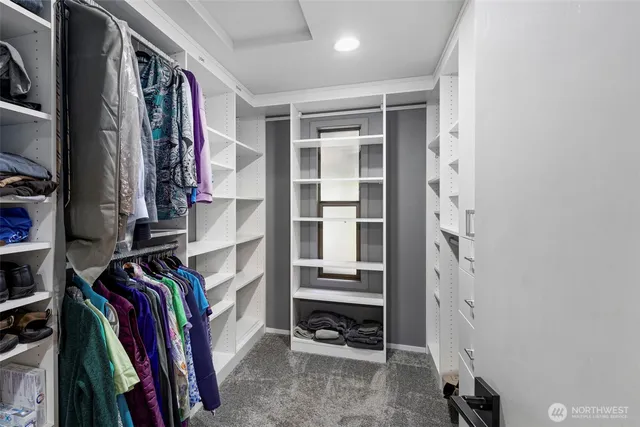 a view of walk in closet with clothes and shoes