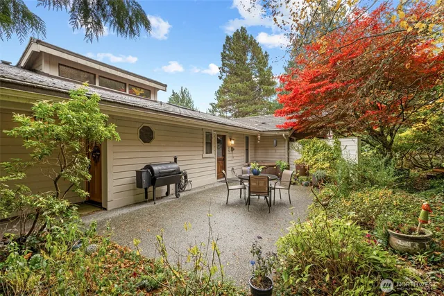 a view of a patio with table and chairs potted plants and large tree