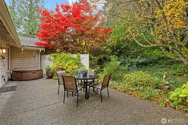 a patio with table and chairs and potted plants
