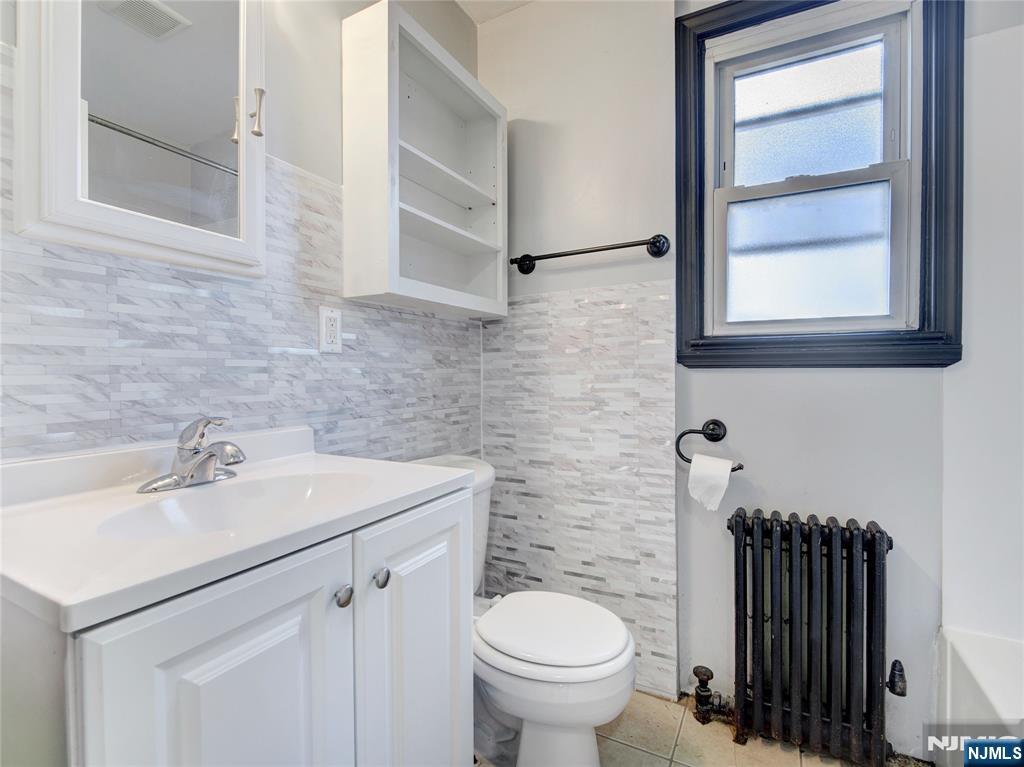176 Teaneck Road Ridgefield Park, NJ 07660 - Photo 10 of 12 a bathroom with a sink toilet and a mirror