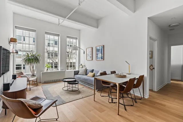 a living room with furniture a wooden floor and floor to ceiling window