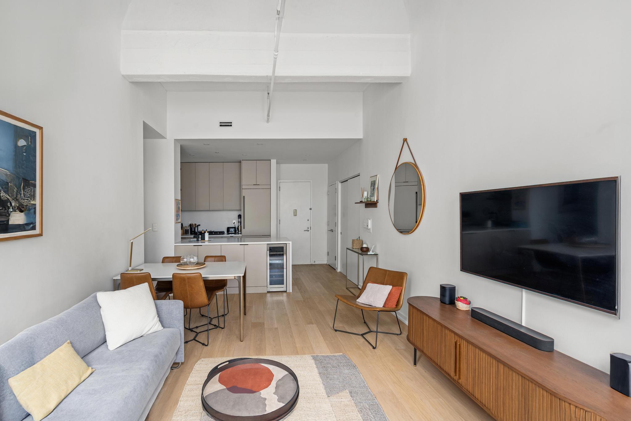 184 Kent Avenue, Unit D319 Brooklyn, NY 11249 - Photo 2 of 14 a living room with furniture a flat screen tv and kitchen view