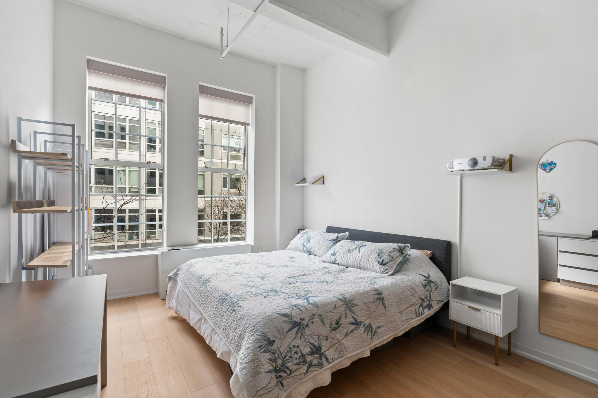 184 Kent Avenue, Unit D319 Brooklyn, NY 11249 - Photo 3 of 14 a bedroom with a bed a couch and large window