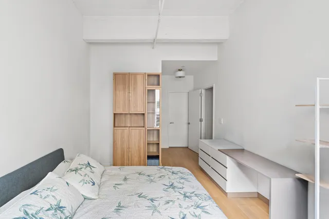 a bedroom with a bed a couch and large window