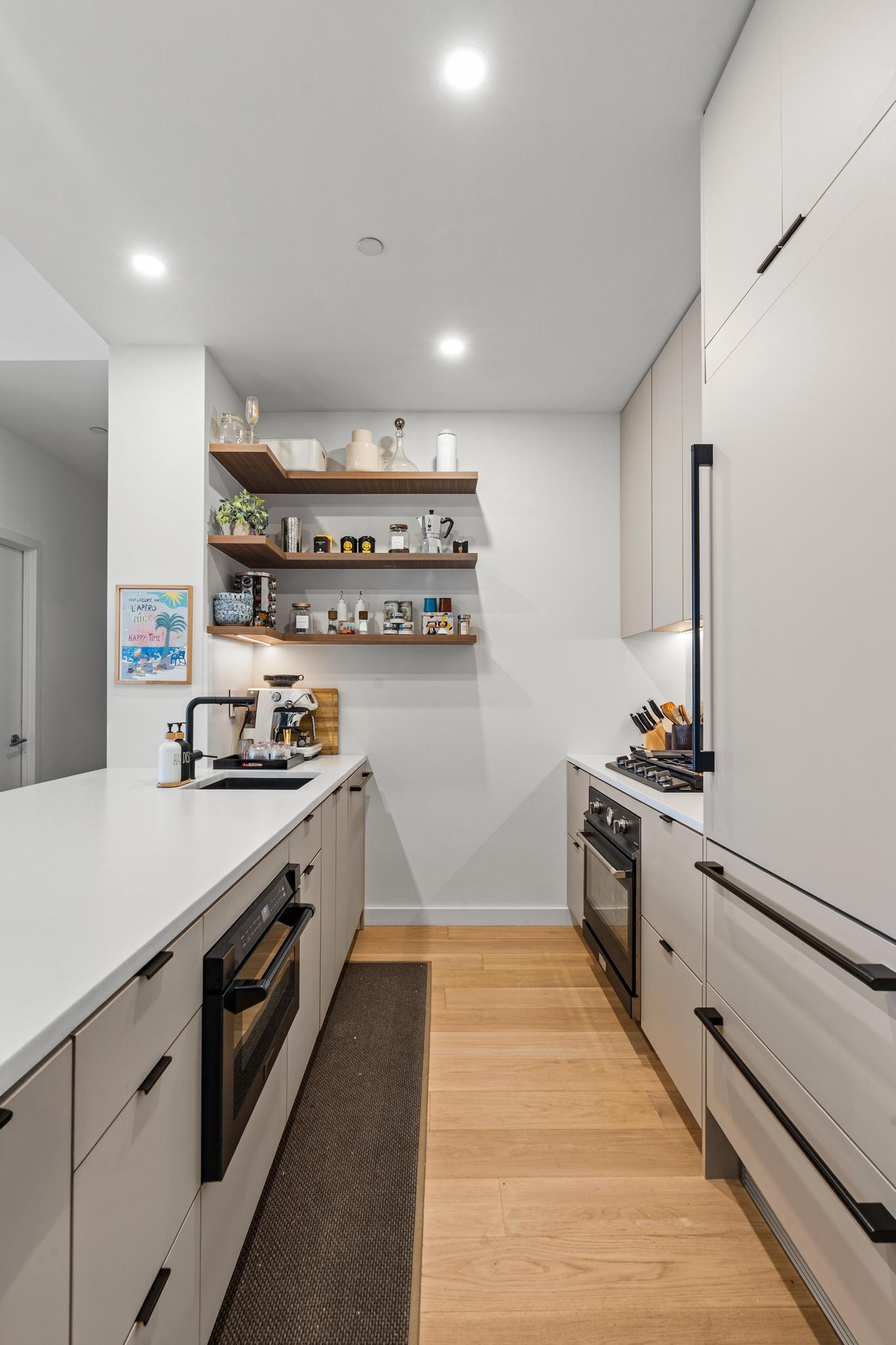 184 Kent Avenue, Unit D319 Brooklyn, NY 11249 - Photo 8 of 14 a large kitchen with stainless steel appliances granite countertop a stove and a sink