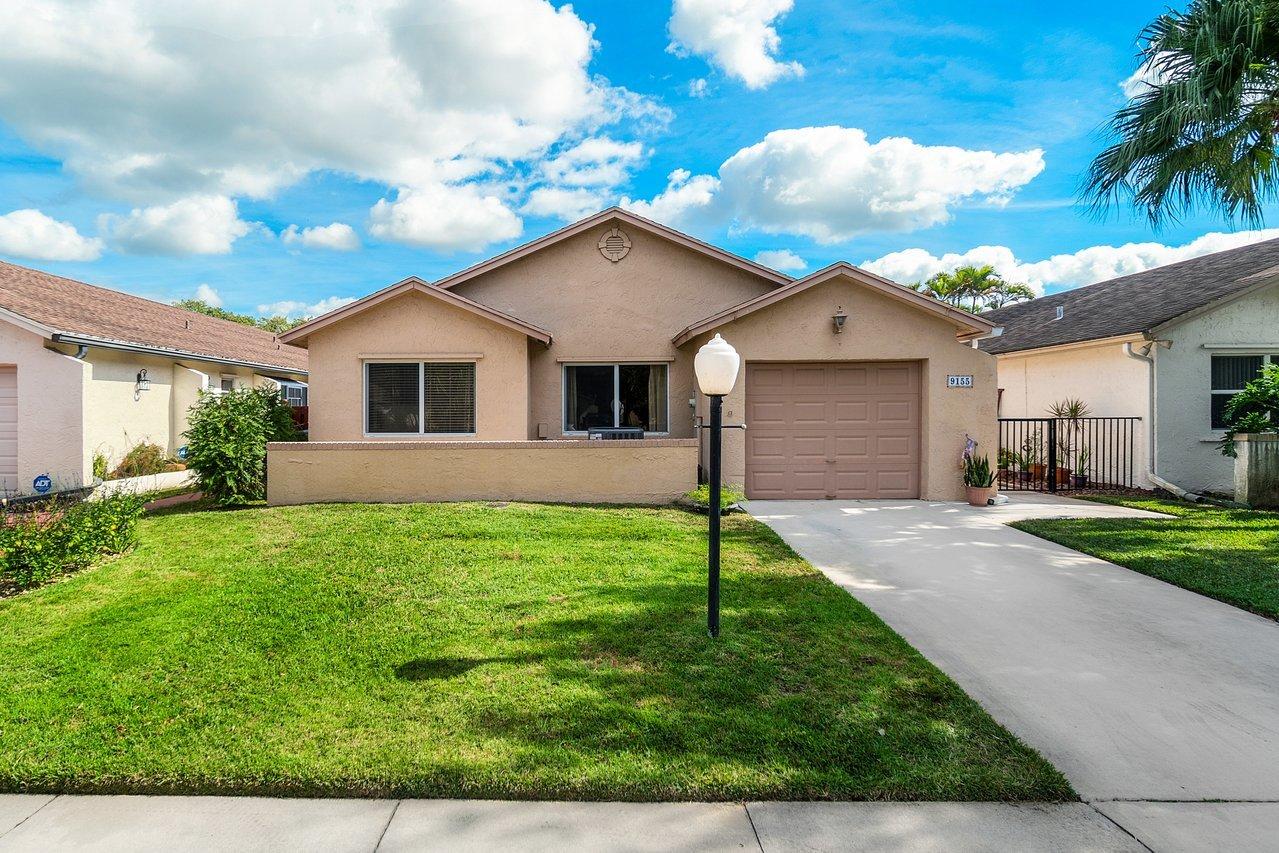 9155 Pine Springs Drive Boca Raton, FL 33428 - Photo 1 of 24 a front view of house with yard and green space