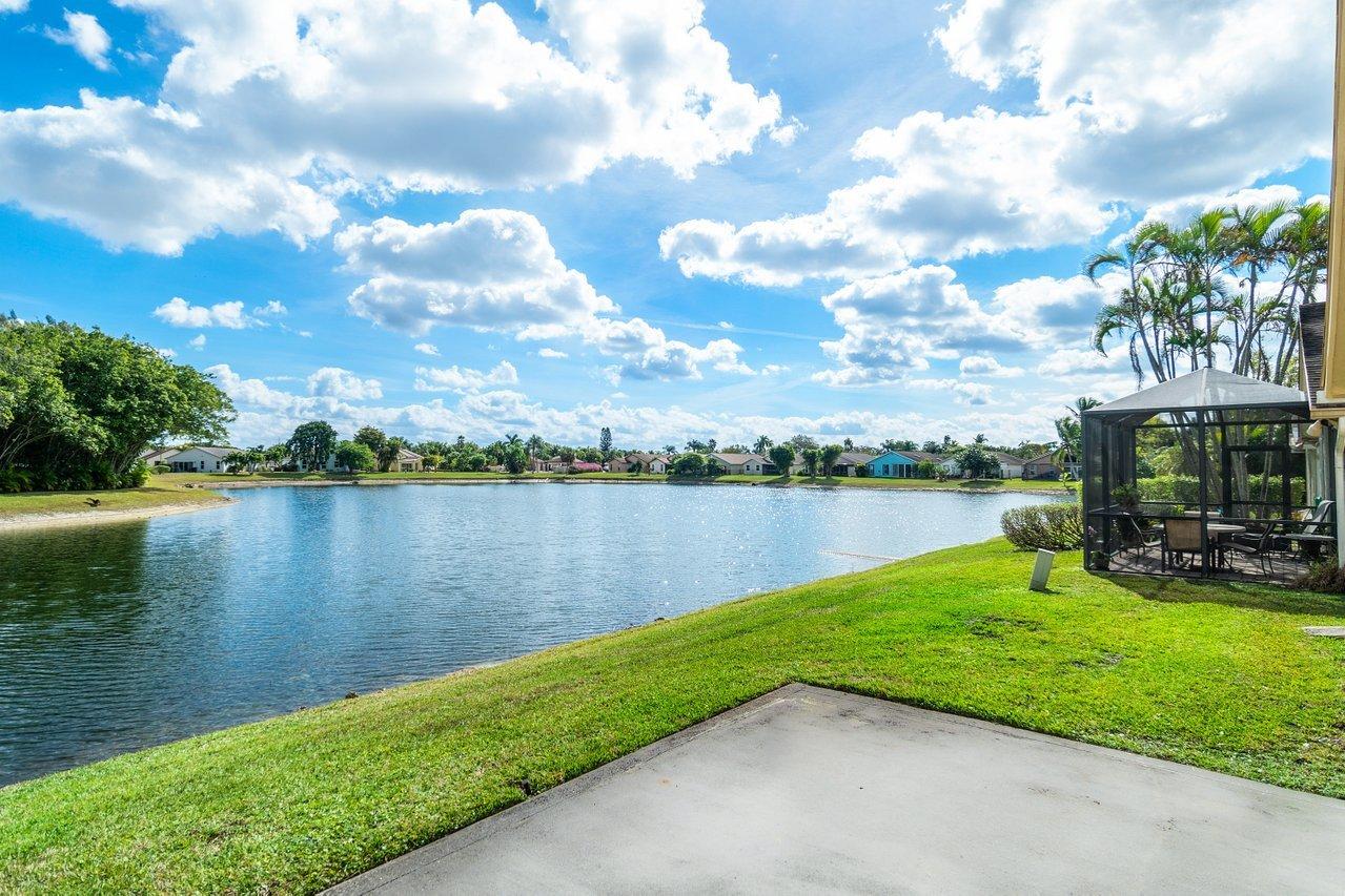 9155 Pine Springs Drive Boca Raton, FL 33428 - Photo 2 of 24 a view of a lake with houses in the back