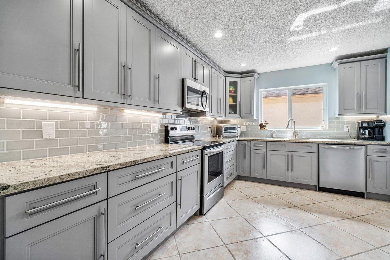 9155 Pine Springs Drive Boca Raton, FL 33428 - Photo 12 of 24 a kitchen with a sink window and cabinets