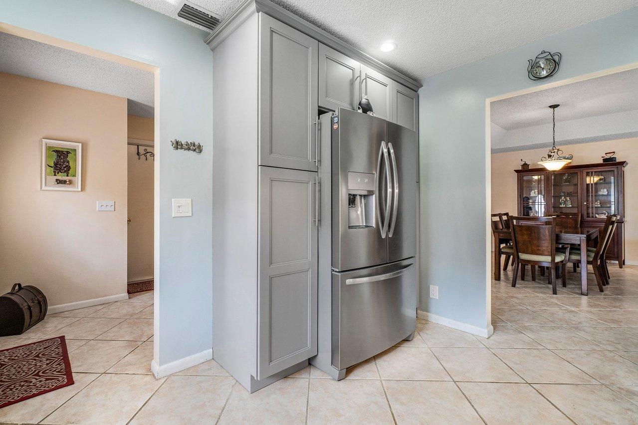 9155 Pine Springs Drive Boca Raton, FL 33428 - Photo 13 of 24 a metallic refrigerator freezer sitting in a kitchen