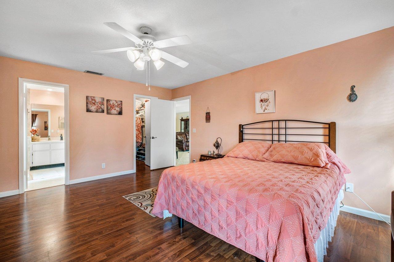 9155 Pine Springs Drive Boca Raton, FL 33428 - Photo 16 of 24 a bedroom with a large bed and a ceiling fan