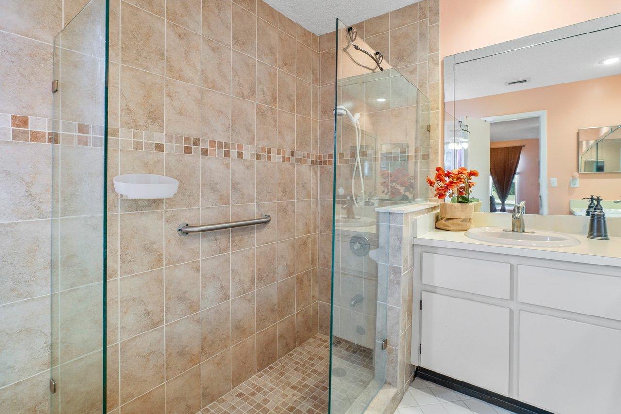 9155 Pine Springs Drive Boca Raton, FL 33428 - Photo 18 of 24 a bathroom with a shower sink and mirror