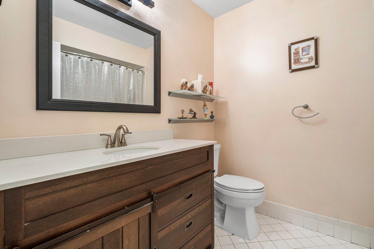 9155 Pine Springs Drive Boca Raton, FL 33428 - Photo 21 of 24 a bathroom with a granite countertop sink mirror vanity and toilet