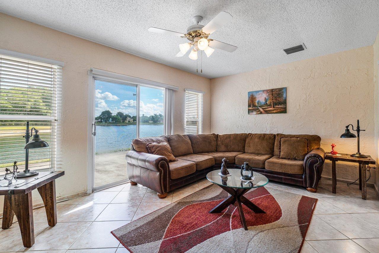 9155 Pine Springs Drive Boca Raton, FL 33428 - Photo 6 of 24 a living room with furniture and a large window