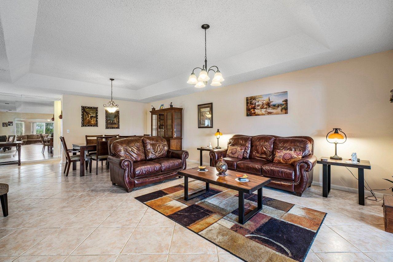 9155 Pine Springs Drive Boca Raton, FL 33428 - Photo 7 of 24 a living room with furniture and a chandelier