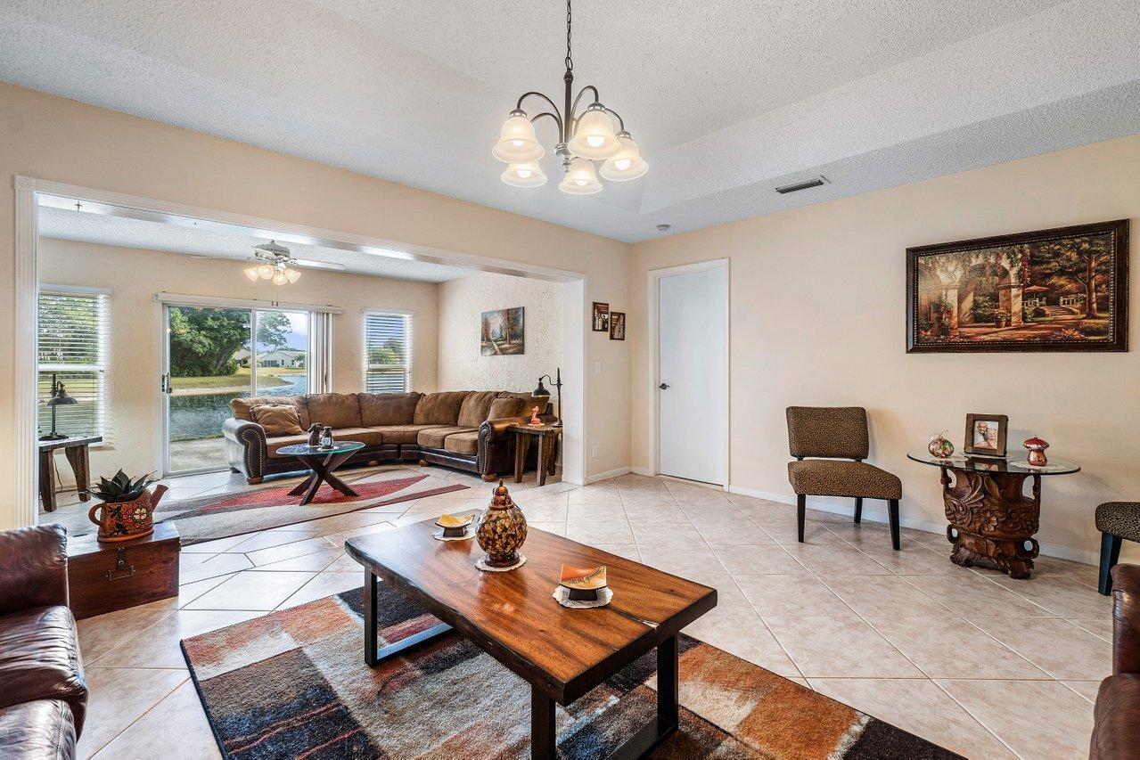 9155 Pine Springs Drive Boca Raton, FL 33428 - Photo 9 of 24 a living room with furniture a table and wooden floor