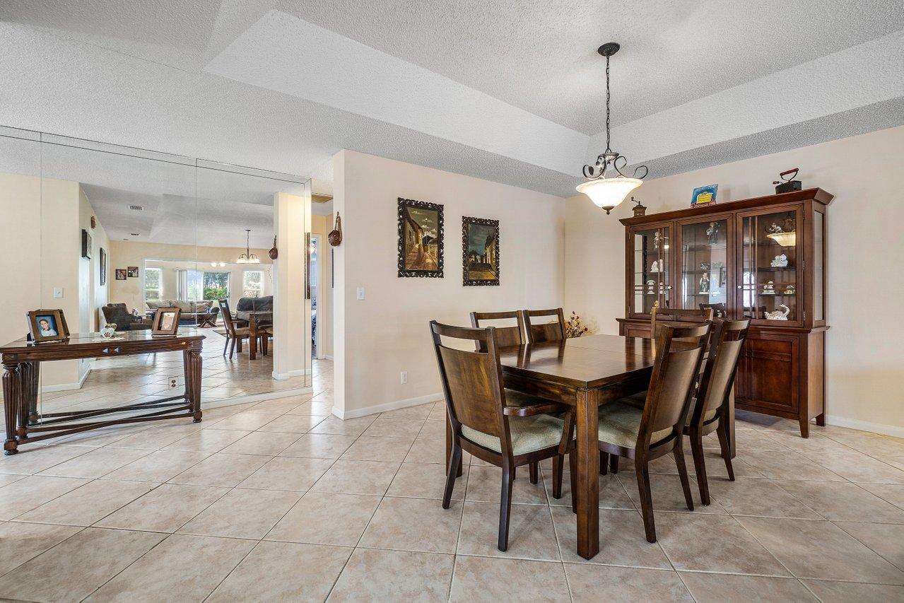 9155 Pine Springs Drive Boca Raton, FL 33428 - Photo 10 of 24 a view of a dining room and livingroom with furniture wooden floor a chandelier
