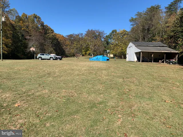 a tall yellow house with a yard