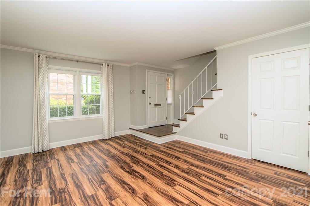 852 McAlway Road Charlotte, NC 28211 - Photo 3 of 26 a view of an empty room with wooden floor and a window