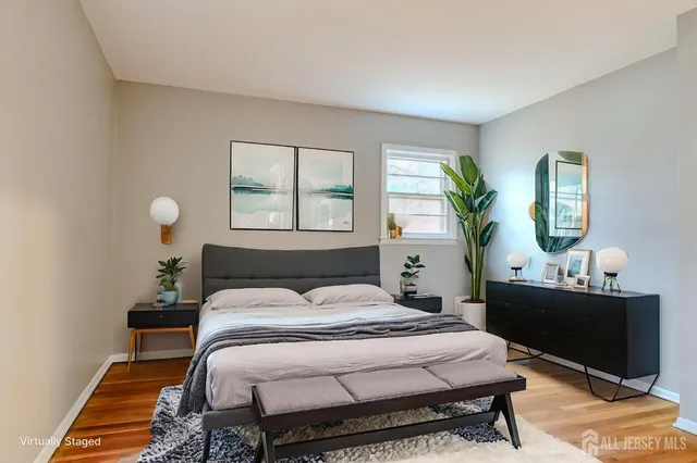 a bedroom with a bed table chair and a window