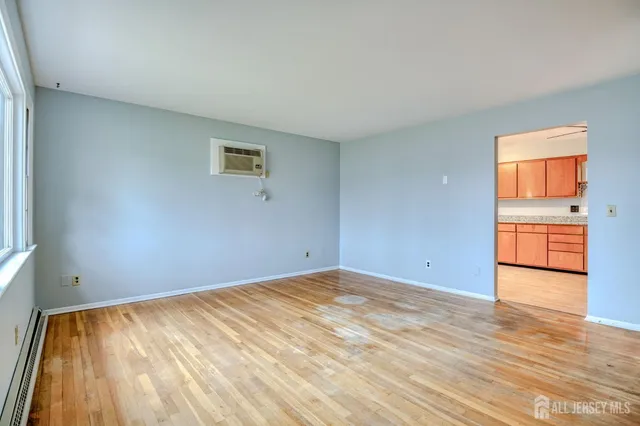 a view of empty room with wooden floor