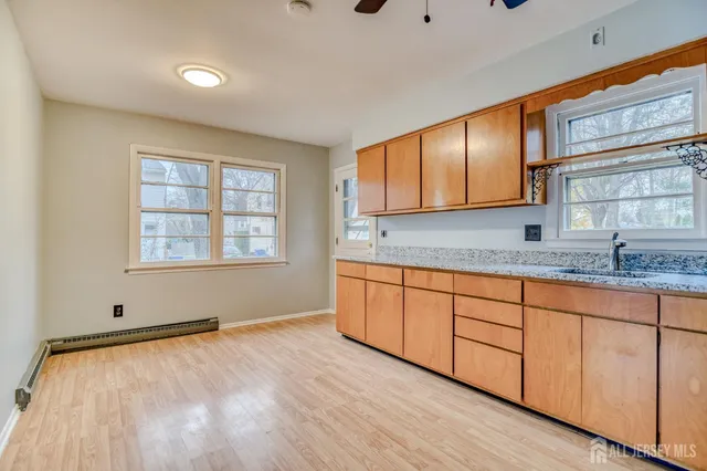 a room with granite countertop wooden cabinets and a sink