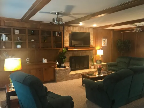 a living room with furniture a flat screen tv and a fireplace