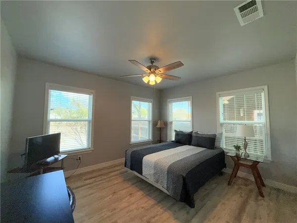 a bedroom with a large bed and a chandelier