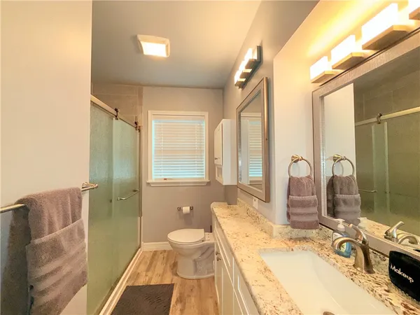 a bathroom with a granite countertop sink toilet and shower