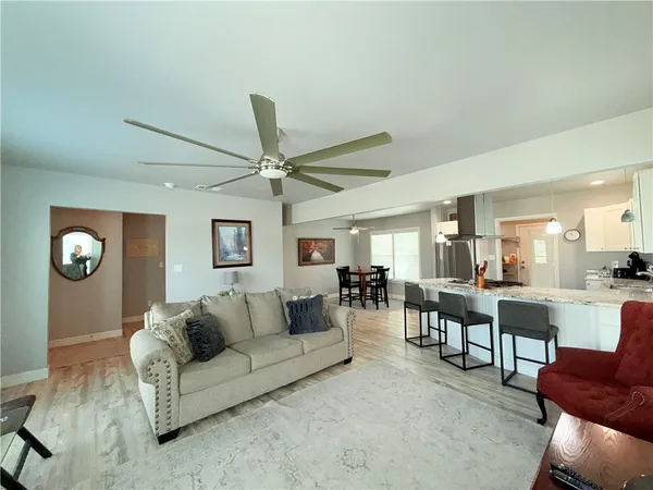 a living room with furniture and a view of kitchen