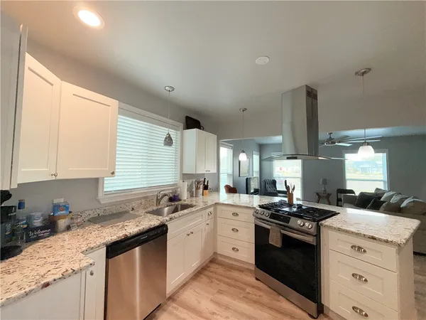a kitchen with a sink stove top oven and cabinets