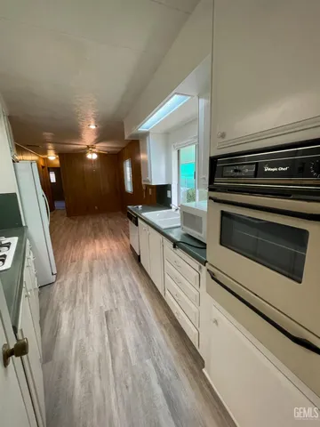 a view of a kitchen with wooden floor and electronic appliances