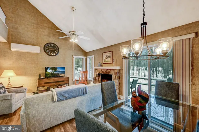 a living room with furniture a fireplace and a floor to ceiling window