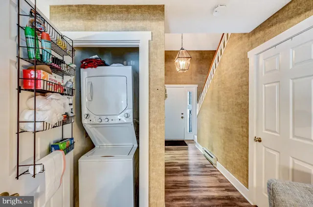 a view of a hallway with wooden floor and front door