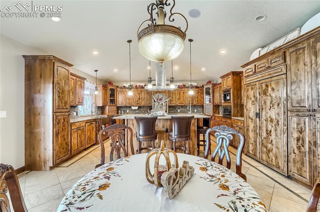 1777 16th Street Greeley, CO 80631 - Photo 14 of 42 a kitchen with stainless steel appliances kitchen island granite countertop a table chairs in it and wooden floors