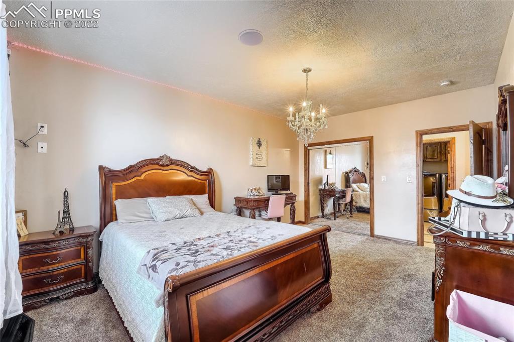 1777 16th Street Greeley, CO 80631 - Photo 23 of 42 a bedroom with a bed and a chandelier