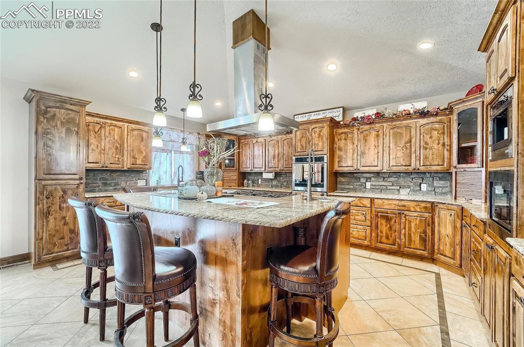 1777 16th Street Greeley, CO 80631 - Photo 9 of 42 a kitchen with granite countertop a table chairs stove and cabinets