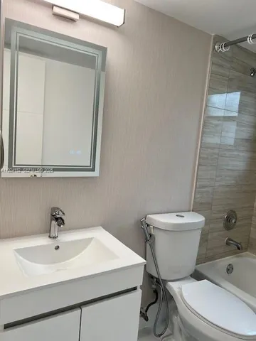 a white toilet sitting next to a bathroom sink